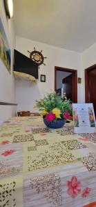 una mesa con un tazón de flores encima en Case Pescatori en Lampedusa