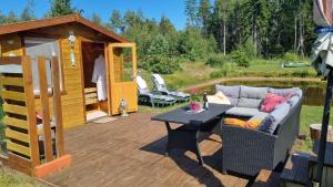 Nõva的住宿－Sillaotsa Talu，平台上设有带沙发和桌子的庭院