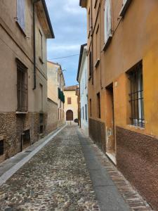 an empty street in an alley between buildings at Domus Flavia in Mantova