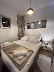 a bedroom with a large white bed with a mirror at Madona di Sinj in Sinj