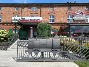 a statue of a train on display in front of a building at Hotel Przystanek Torun in Toruń