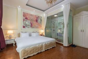 a bedroom with a large white bed and a shower at My Moon Hotel Hanoi in Hanoi