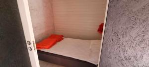 a small room with a small bed with an orange blanket at Lygnareds Camping in Alingsås