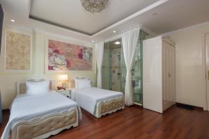 a bedroom with two beds and a shower at My Moon Hotel Hanoi in Hanoi