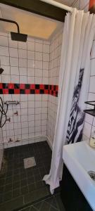 a bathroom with a shower curtain and a sink at Lygnareds Camping in Alingsås
