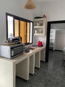 a kitchen with a counter with a microwave at Appartement 3 Riad Dar Samar in Tamraght Ouzdar
