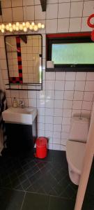 bagno con servizi igienici, lavandino e specchio di Lygnareds Camping ad Alingsås