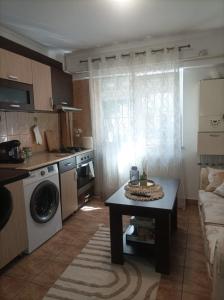 a small kitchen with a table and a couch at Apartament Florina in Râmnicu Vâlcea