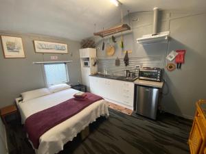 una piccola cucina con un letto in una camera di On the water boat House a Whangarei
