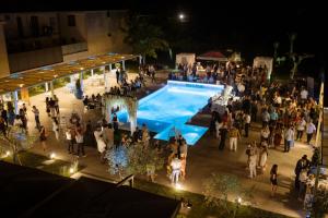 Une foule de gens debout autour d'une piscine la nuit dans l'établissement Hotel St. Giorgio, à Castel San Giorgio