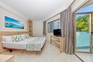 a bedroom with a bed and a tv and a window at Leonardo Suites Hotel Mallorca Calvia in Torrenova