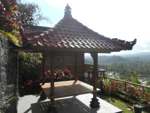 a wooden gazebo with a roof on a balcony at Villa Dukuh in Selat