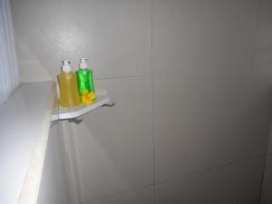 ein Badezimmer mit zwei Flaschen auf einem Regal an der Wand in der Unterkunft Villa Dukuh in Selat