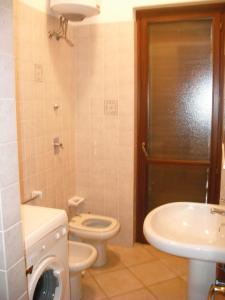 a bathroom with a toilet and a sink and a shower at Case Paseda Acquamarina in San Vito lo Capo