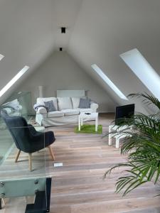ein Wohnzimmer mit einem Sofa und einem Stuhl in der Unterkunft Außergewöhnlich Ferienwohnung im Villenviertel in Wilhelmshaven