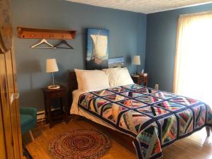 sypialnia z łóżkiem i niebieską ścianą w obiekcie Valhalla near L'Anse aux Meadows w mieście L'Anse aux Meadows