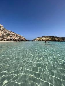 a large body of water with a group of people in it at Casa vacanze LIMU in Lampedusa