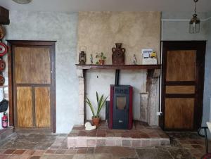 a living room with a tv in a room with two doors at Mine d'Ore Petit Gîte de la Chouette d'Or in Thoste