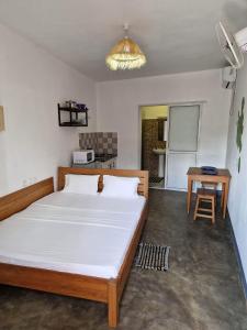 ein Schlafzimmer mit einem großen Bett und einem Tisch in der Unterkunft Hotel de la Plage in Nosy Be