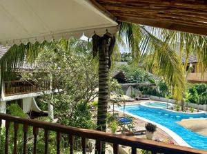 a view of a resort with a pool and a palm tree at Mr Kahawa Waterfront Suites in Paje