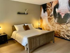 1 dormitorio con 1 cama y una foto de una vaca en Camping Lagewald Vakantiehuis, en Groesbeek