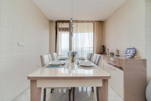 uma cozinha com uma grande mesa branca e cadeiras em Apartcomplex Golden Bay em Ravda