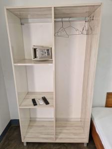 a book shelf with a microwave on it at Hotel de la Plage in Nosy Be