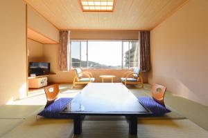 a room with a table and chairs and a large window at Ooedo Onsen Monogatari Hotel Kinugawa Gyoen in Nikko