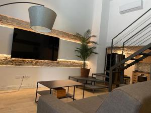 uma sala de estar com um sofá, uma mesa e uma televisão em Loft Marconi 34 em Soverato Marina