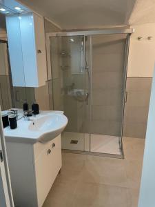 uma casa de banho com uma cabina de duche em vidro e um lavatório. em Loft Marconi 34 em Soverato Marina