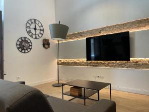 uma sala de estar com um sofá, uma televisão e uma mesa em Loft Marconi 34 em Soverato Marina