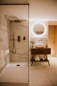 y baño con lavabo y ducha acristalada. en chambre d'hôte doux moment spa privatif en Maresches