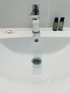 ein weißes Waschbecken mit einem Wasserhahn darüber in der Unterkunft DXN Luxury Studio 3 in Năvodari