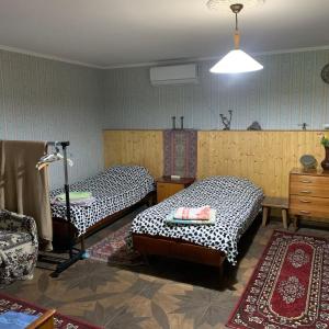Pokój z dwoma łóżkami i komodą oraz pokój z: w obiekcie Sofya w mieście Sighnaghi