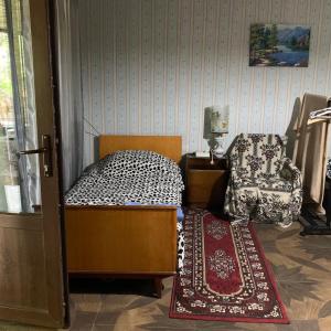 niewielka sypialnia z łóżkiem i krzesłem w obiekcie Sofya w mieście Sighnaghi