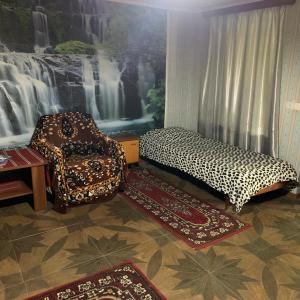salon z łóżkiem, krzesłem i dywanem w obiekcie Sofya w mieście Sighnaghi