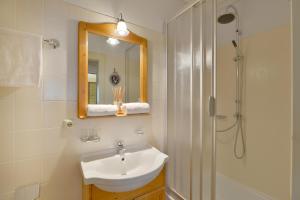 a bathroom with a sink and a mirror and a shower at Chalet Grizzly in Ellmau