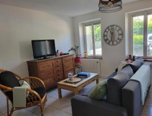 sala de estar con sofá azul y TV en Appartement avec terrasse en Gaillon