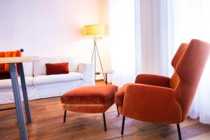 uma sala de estar com duas cadeiras e um sofá em Stadtjuwel am Neusiedlersee em Rust