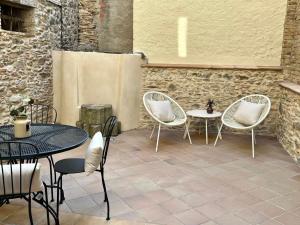 un patio avec trois chaises, une table et deux tables dans l'établissement Apartaments Can Gibert, à Castelló d'Empúries