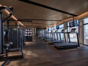 a gym with a row of treadms and machines at Bay Capital Danang in Danang