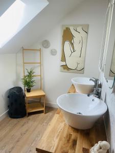 a bathroom with a white tub and a sink at Logement A / Clos des Saunières in Bligny-lès-Beaune