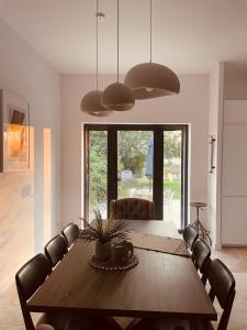 a dining room with a wooden table and chairs at Logement A / Clos des Saunières in Bligny-lès-Beaune