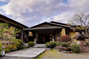 une maison avec une porte et des escaliers menant à l'entrée dans l'établissement Tatsuta Ryokan, à Izu