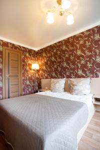 a bedroom with a large white bed with floral wallpaper at Двушка люкс автовокзал in Mykolaiv