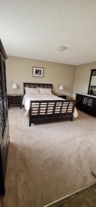 a bedroom with a large bed and two night stands at Spacious comfortable Air-Conditioned. Near airport! in Calgary