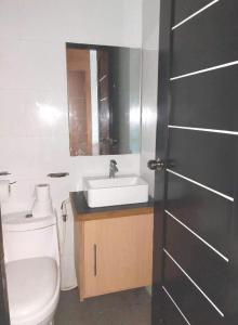 La salle de bains est pourvue de toilettes blanches et d'un lavabo. dans l'établissement Villa Tomasa 2, Panglao, à Panglao