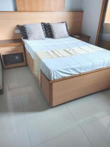1 dormitorio con cama con marco de madera y mesita de noche en Villa Tomasa 2, Panglao en Panglao City