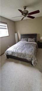1 dormitorio con 1 cama y ventilador de techo en Spacious comfortable Air-Conditioned. Near airport! en Calgary