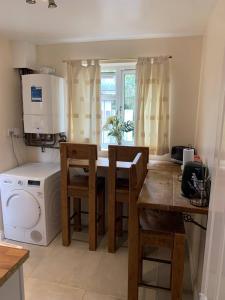 a kitchen with a table and a washing machine at Oak in Whetstone